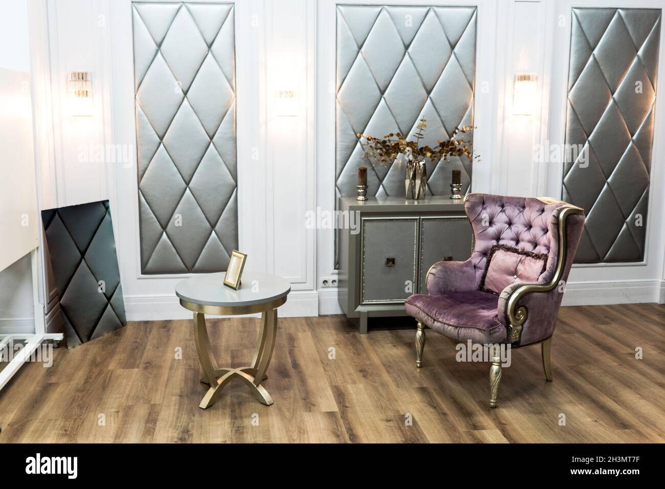 Maison de luxe avec beau fauteuil matelassé violet petite table et commode. Intérieur élégant Banque D'Images Maison de luxe avec beau fauteuil matelassé violet petite table et commode. Intérieur élégant Banque D'Images