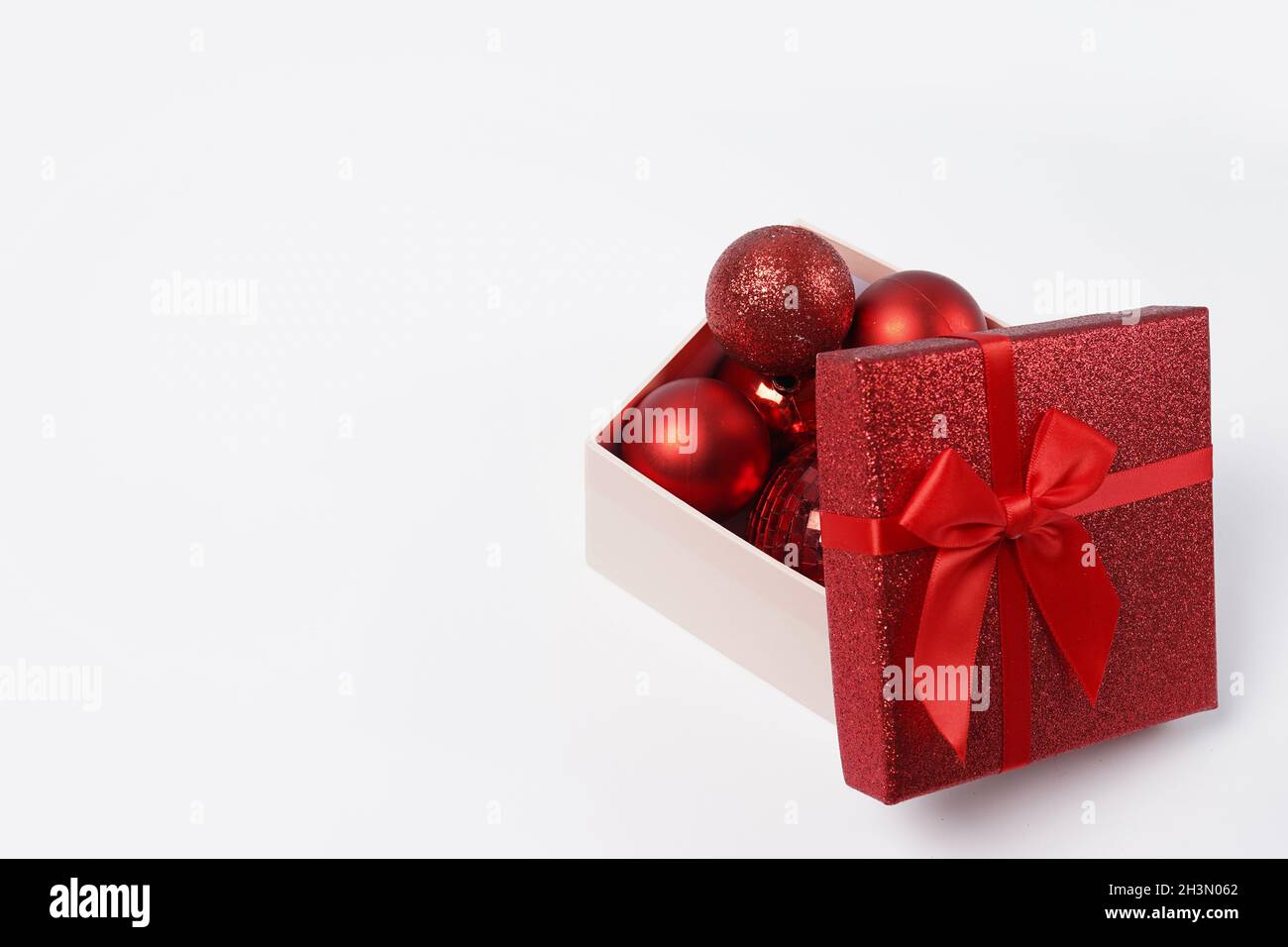 boîte cadeau de noël avec boules rouges et noeud isolé sur fond blanc, espace copie .Carte de vœux du nouvel an Banque D'Images