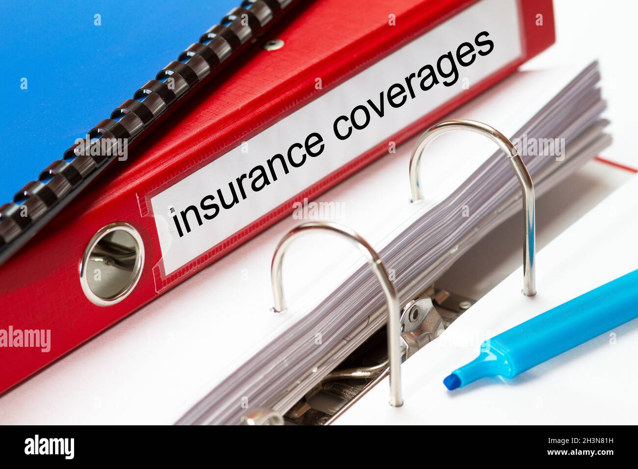 grande chemise rouge pour les documents d'assurance, y compris la reliure à anneaux bleus et le fabricant bleu Banque D'Images