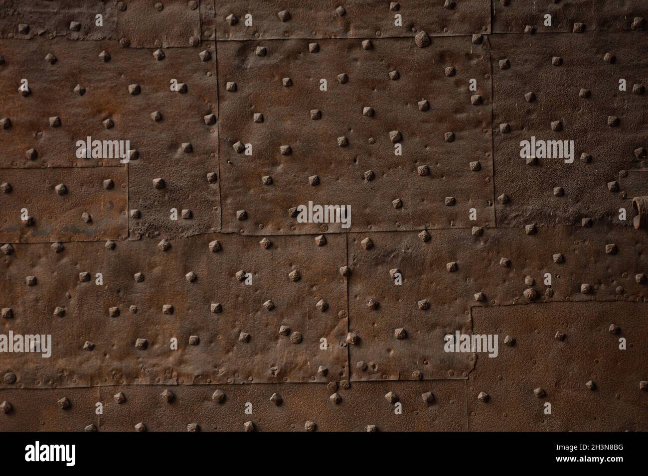 Métal oxydé antique avec rivets. Mur en fer brun rouillé. Grunge la texture ou l'arrière-plan Banque D'Images