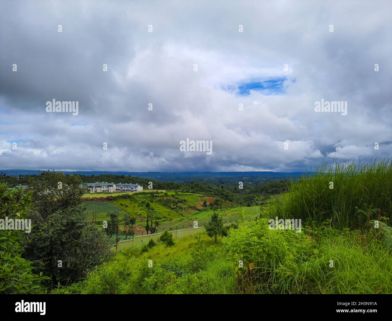 village isolé vert ferme paysage avec lourds nuages le matin Banque D'Images