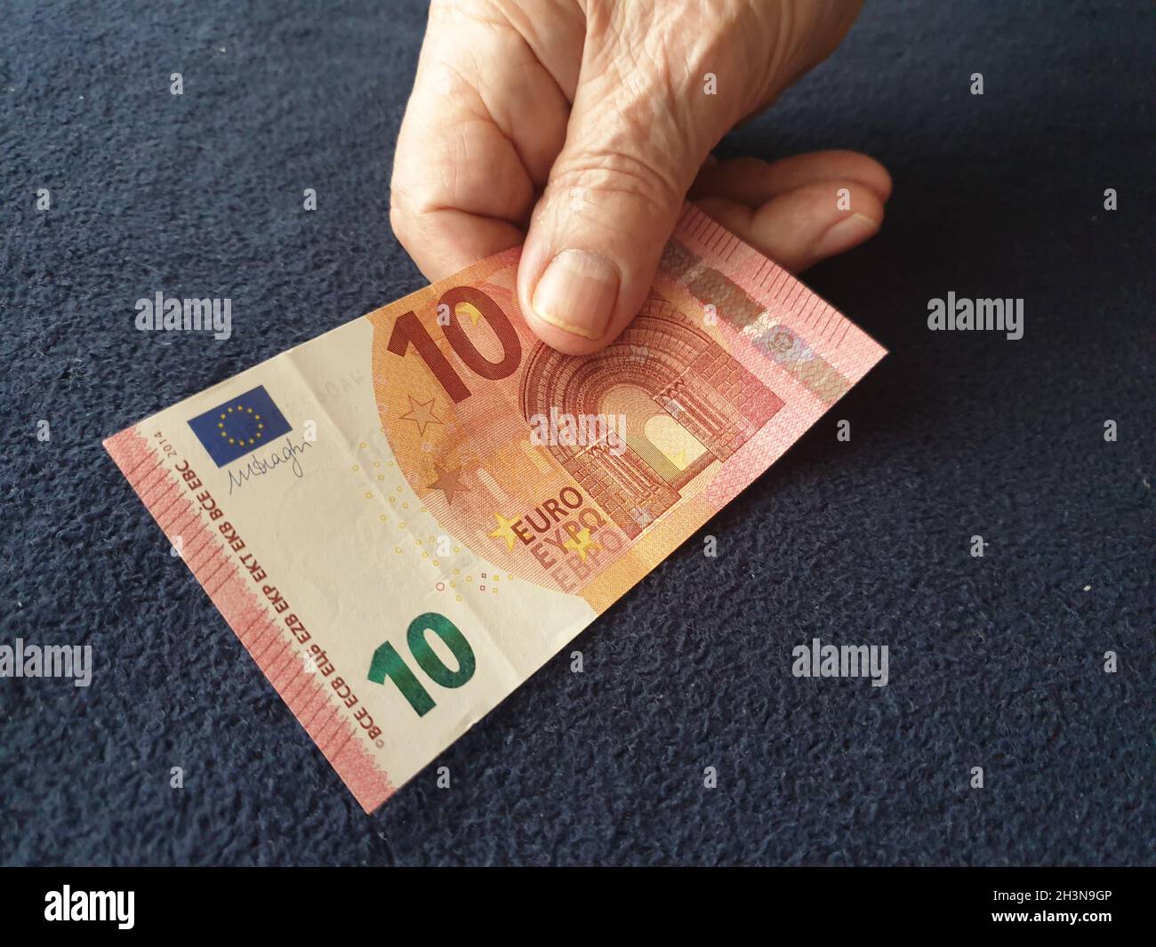 Alter Mann bezahlt mit 10 Euro-Schein Banque D'Images