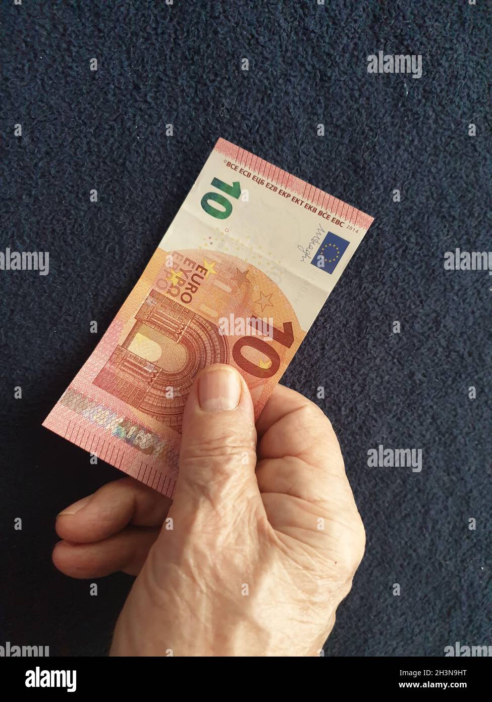 Alter Mann bezahlt mit 10 Euro-Schein Banque D'Images