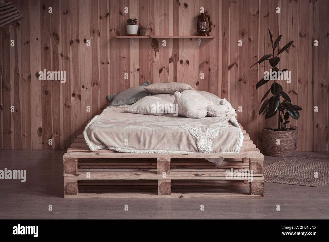 Lit simple et confortable dans un appartement en bois. Vue avant. Endroit confortable ou espace de repos Banque D'Images