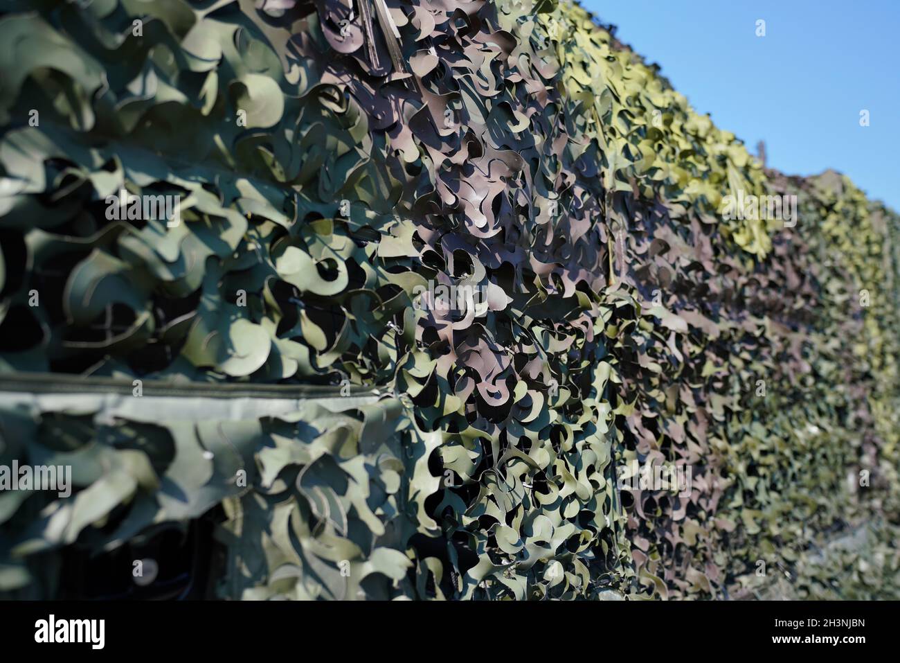 Véhicule militaire blindé recouvert de mesh en tissu camouflage, détail en gros plan Banque D'Images