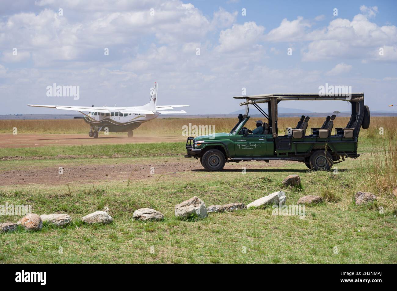 Le 4x4 Toyota Landcruiser safari véhicule attend comme un avion-taxi léger sur la piste d'atterrissage de Musiara, Masai Mara, Kenya Banque D'Images