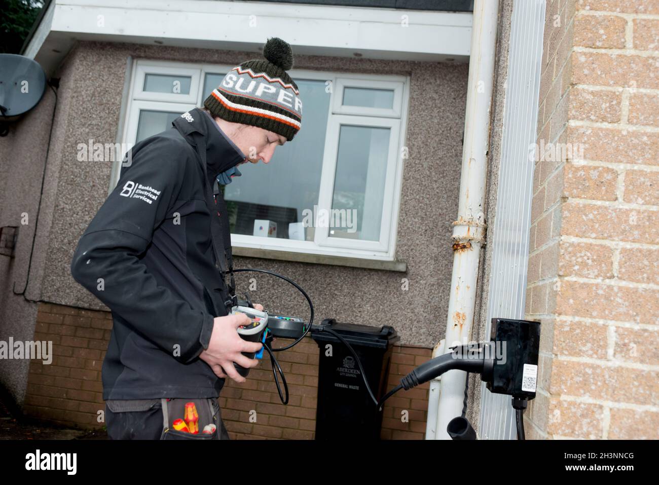 Installation d'un point de recharge de voiture électrique sur une maison à Aberdeen en Écosse Banque D'Images