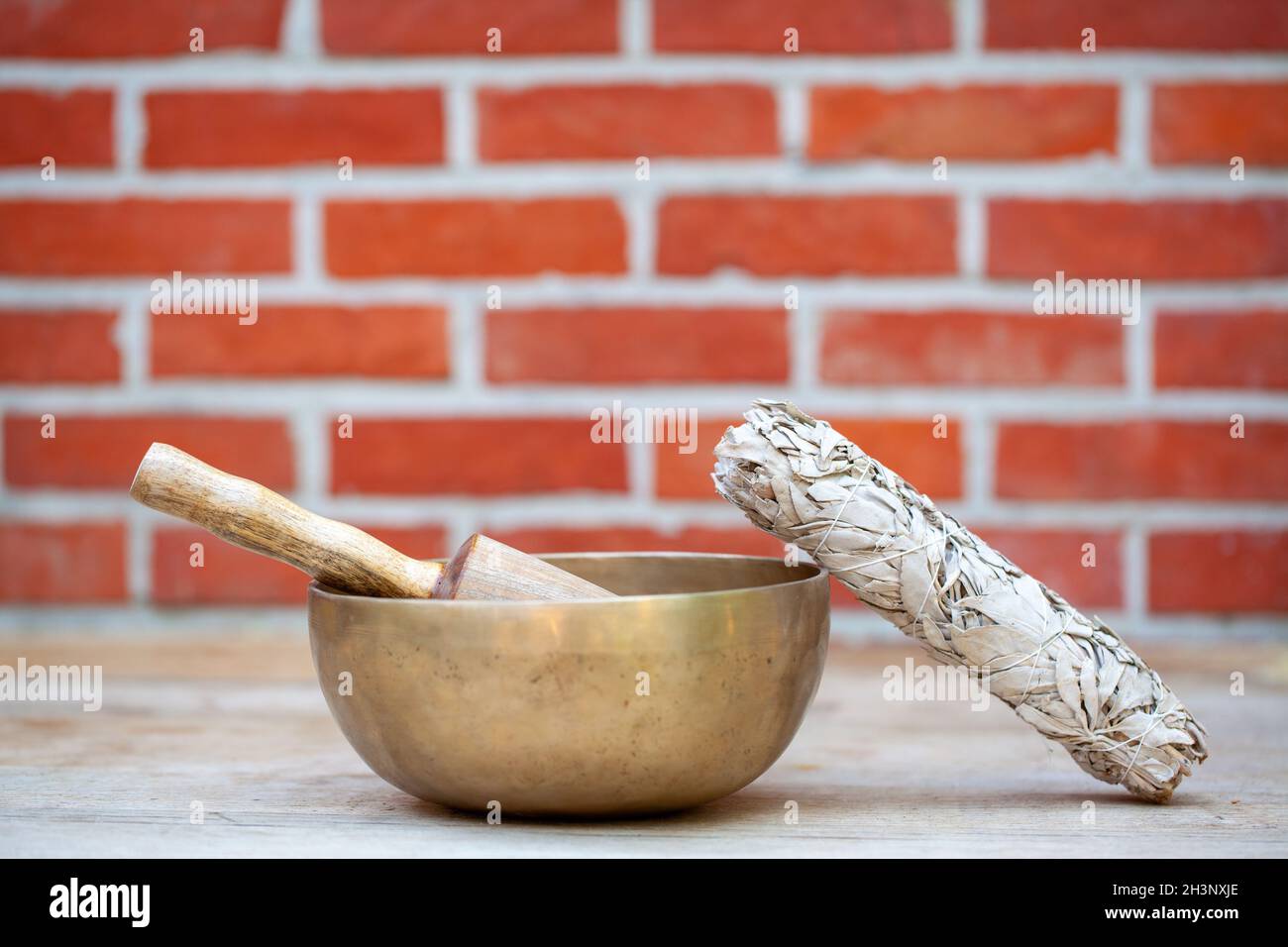 Bols de chant tibétains avec bâtons et bâton de tache sur le fond de mur - instruments de musique pour la méditation, la détente après y Banque D'Images