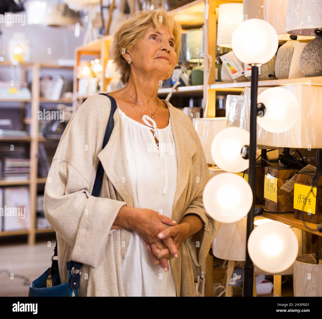 Une femelle choisit un lustre ou une lampe dans un magasin d'électricité  Photo Stock - Alamy