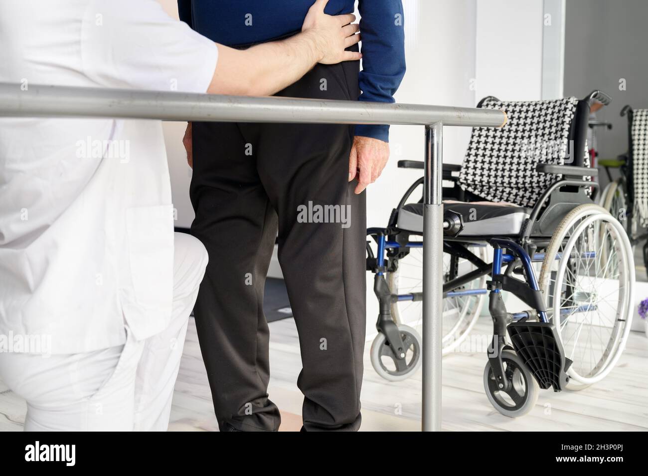 Homme âgé assisté par un physiothérapeute au centre de réadaptation. Banque D'Images