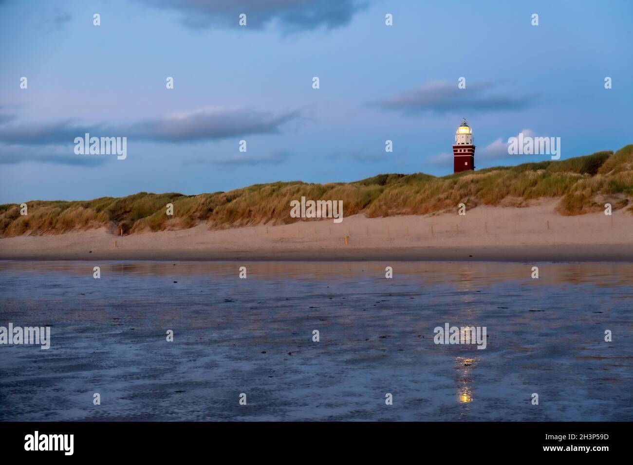 Phare situé sur la côte hollandaise avec un spectaculaire. Et coloré crépuscule ou ciel d'aube derrière elle Banque D'Images