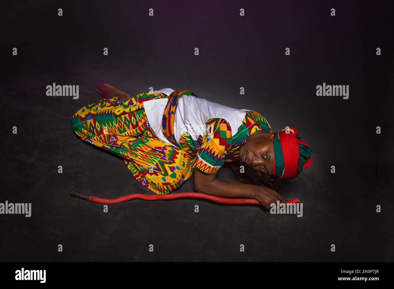 Homme africain dans les vêtements traditionnels souriant, sur fond gris Banque D'Images