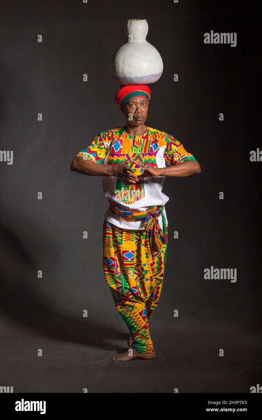 Homme africain dans les vêtements traditionnels souriant, sur fond gris Banque D'Images