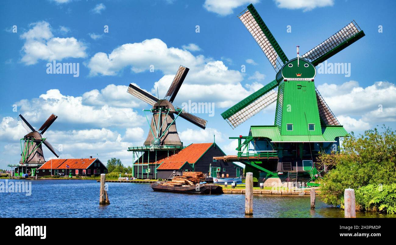 Moulin à vent hollandais dans la campagne verte près d'Amsterdam, pays-Bas, avec ciel bleu et eau de rivière. Banque D'Images