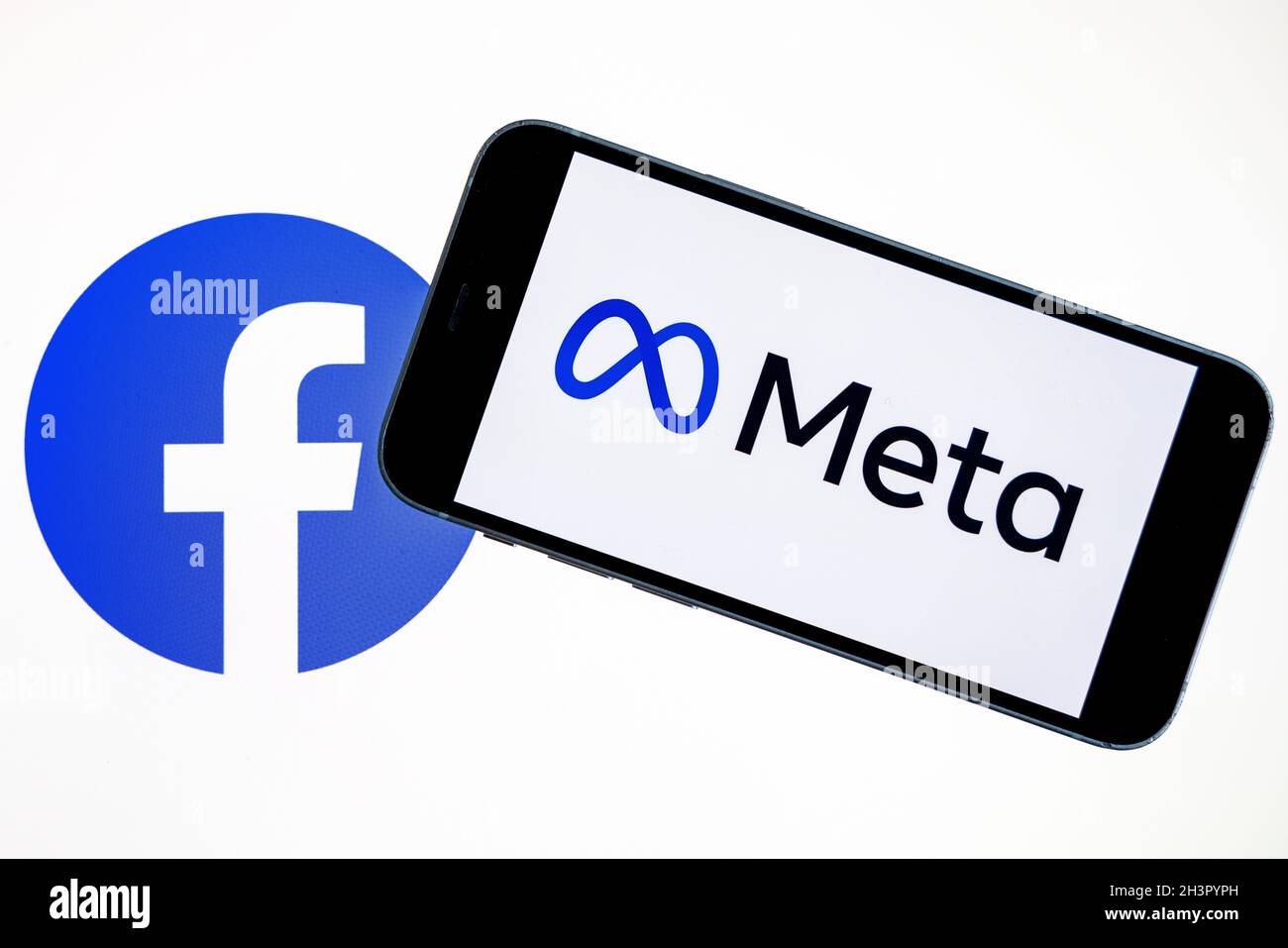 LE logo DE LA SOCIÉTÉ META est visible sur le smartphone en main avec le logo Facebook sur l'écran d'arrière-plan.Nouveau logotype de la société Facebook pour MÉTAVERSE. Banque D'Images