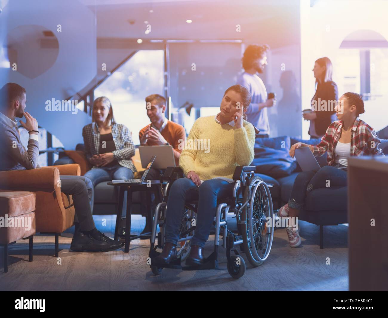 Portrait d'une femme d'affaires handicapée en fauteuil roulant devant son équipe professionnelle diversifiée au bureau Banque D'Images