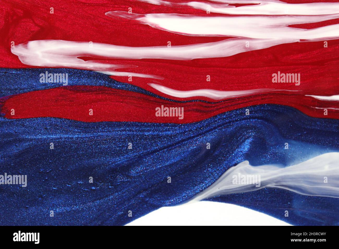 Vernis à ongles rouge, blanc et bleu renversé sur blanc Banque D'Images
