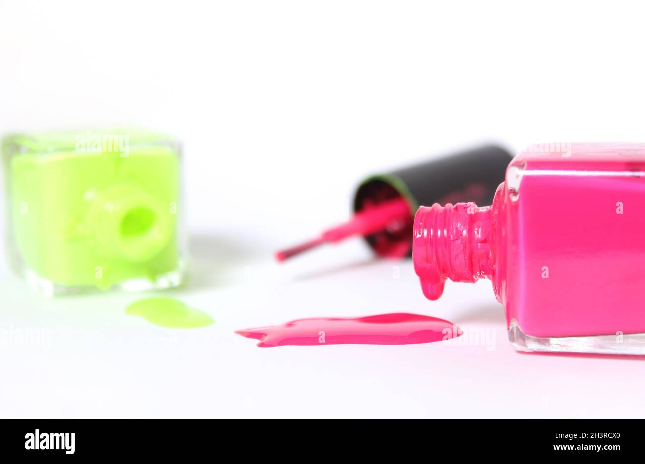 Vernis à ongles néons rose et jaune sur blanc Banque D'Images