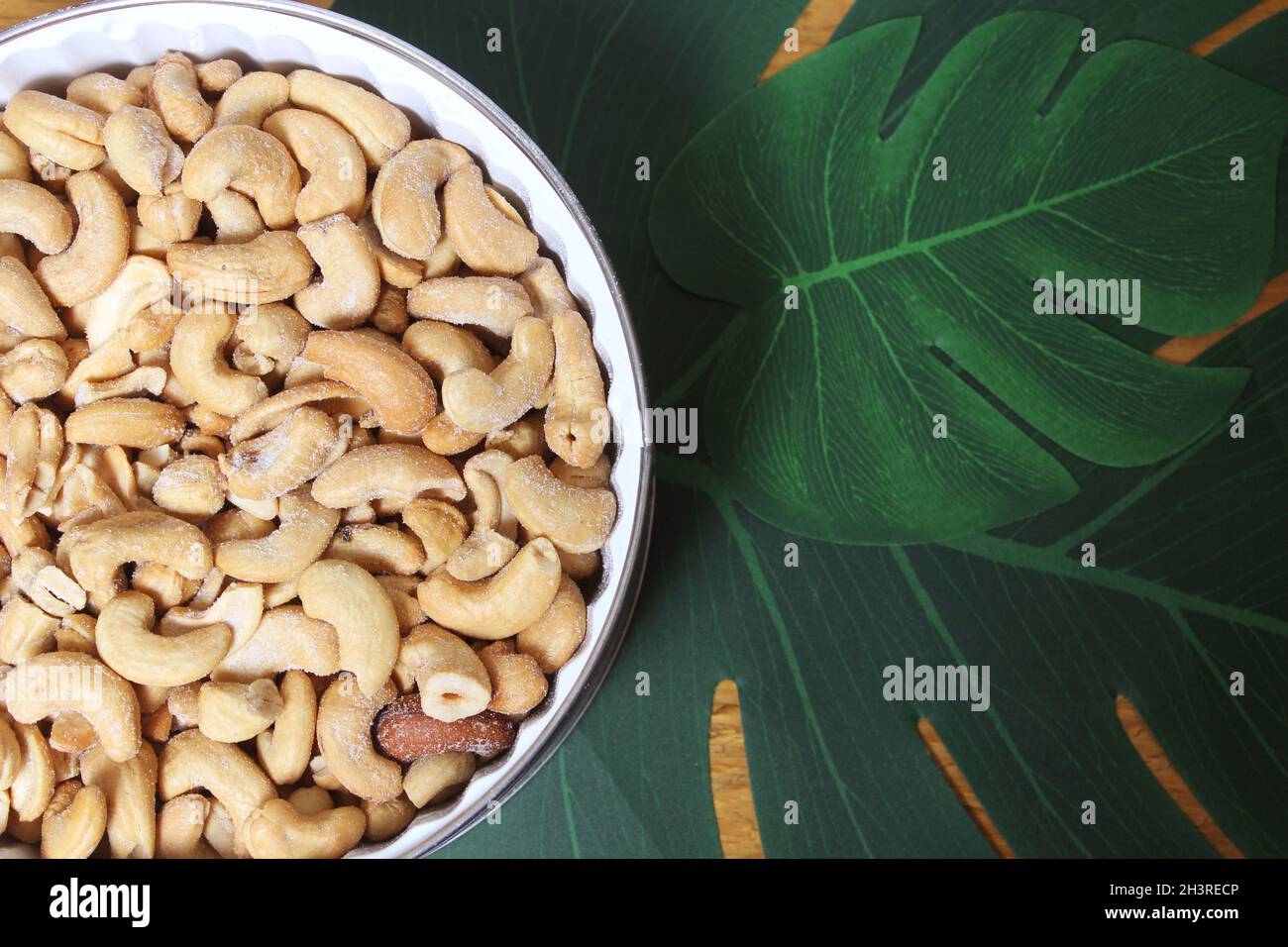 Bol de noix de cajou salées avec fond en bois Banque D'Images