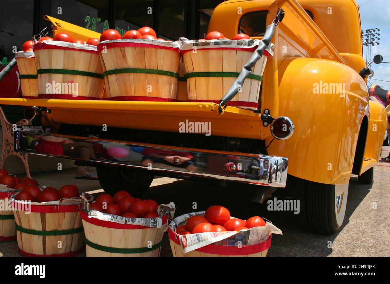 Camion jaune vintage avec paniers de tomates rouges Banque D'Images