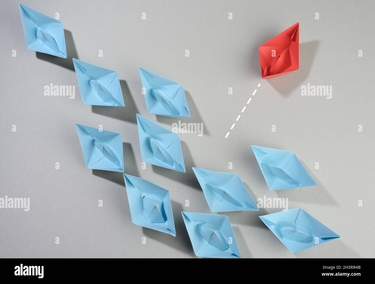 Groupe de bateaux en papier sur fond gris.Le concept de pensée hors de la boîte, l'unicité. Banque D'Images