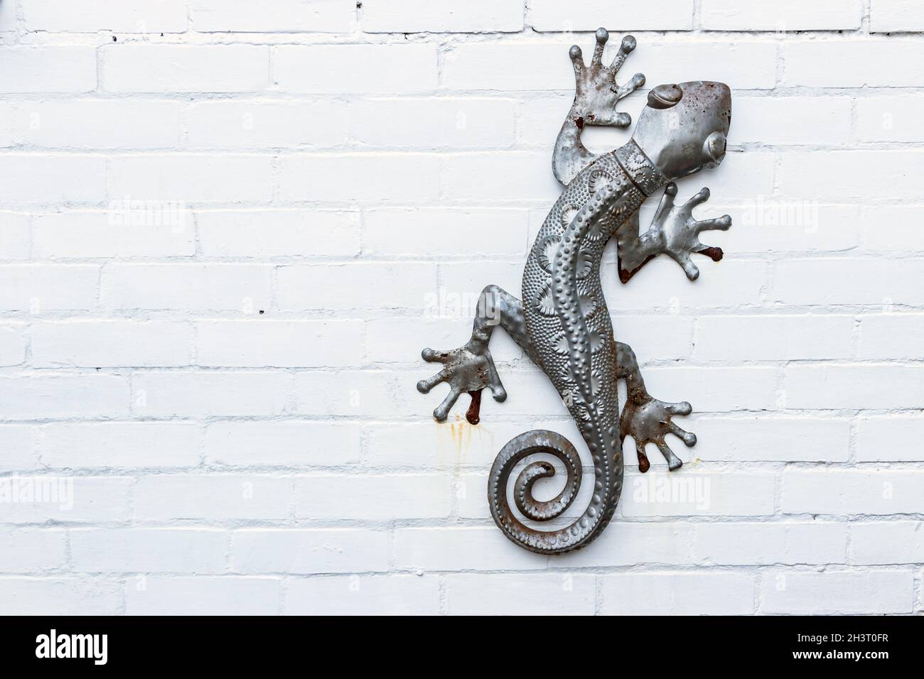 sculpture en métal d'un lézard gecko salamandre isolé sur un mur de briques  peintes en blanc Photo Stock - Alamy
