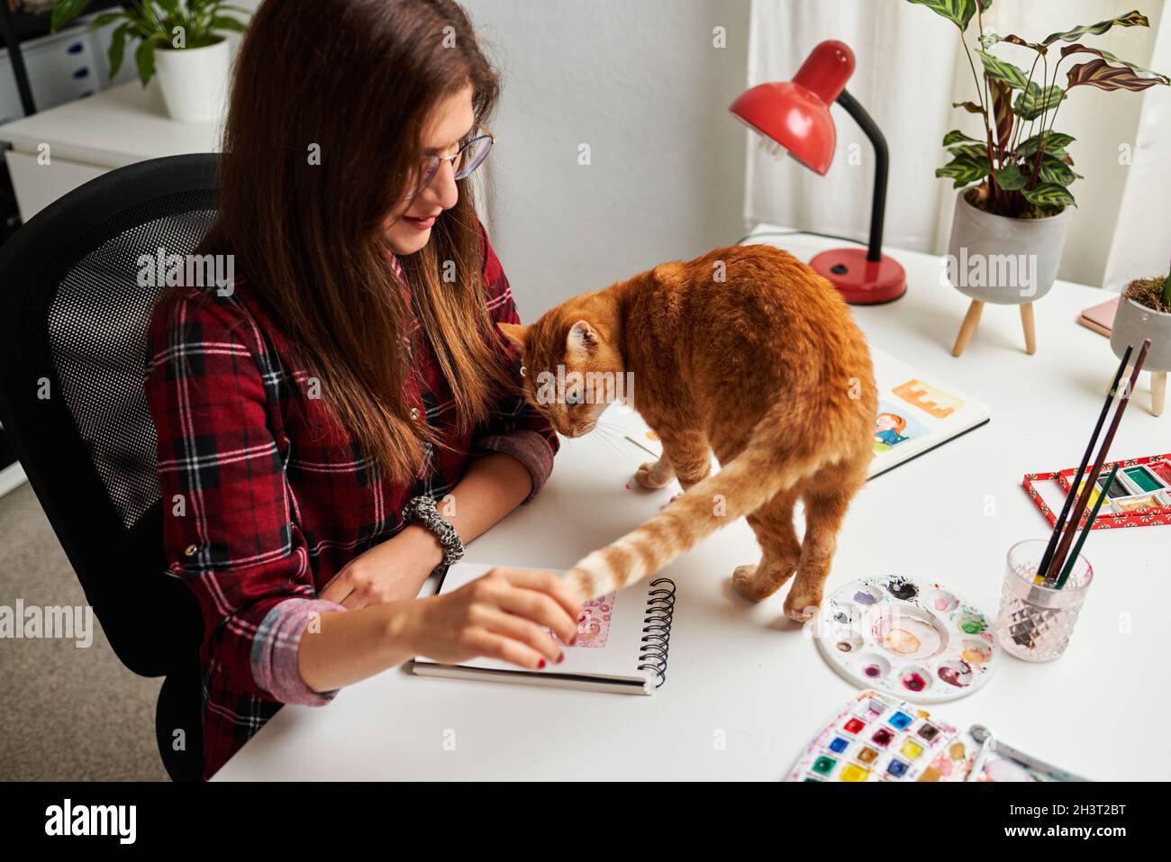 Une femme créative a fait un travail avec son chat sur le bureau de son bureau à domicile Banque D'Images