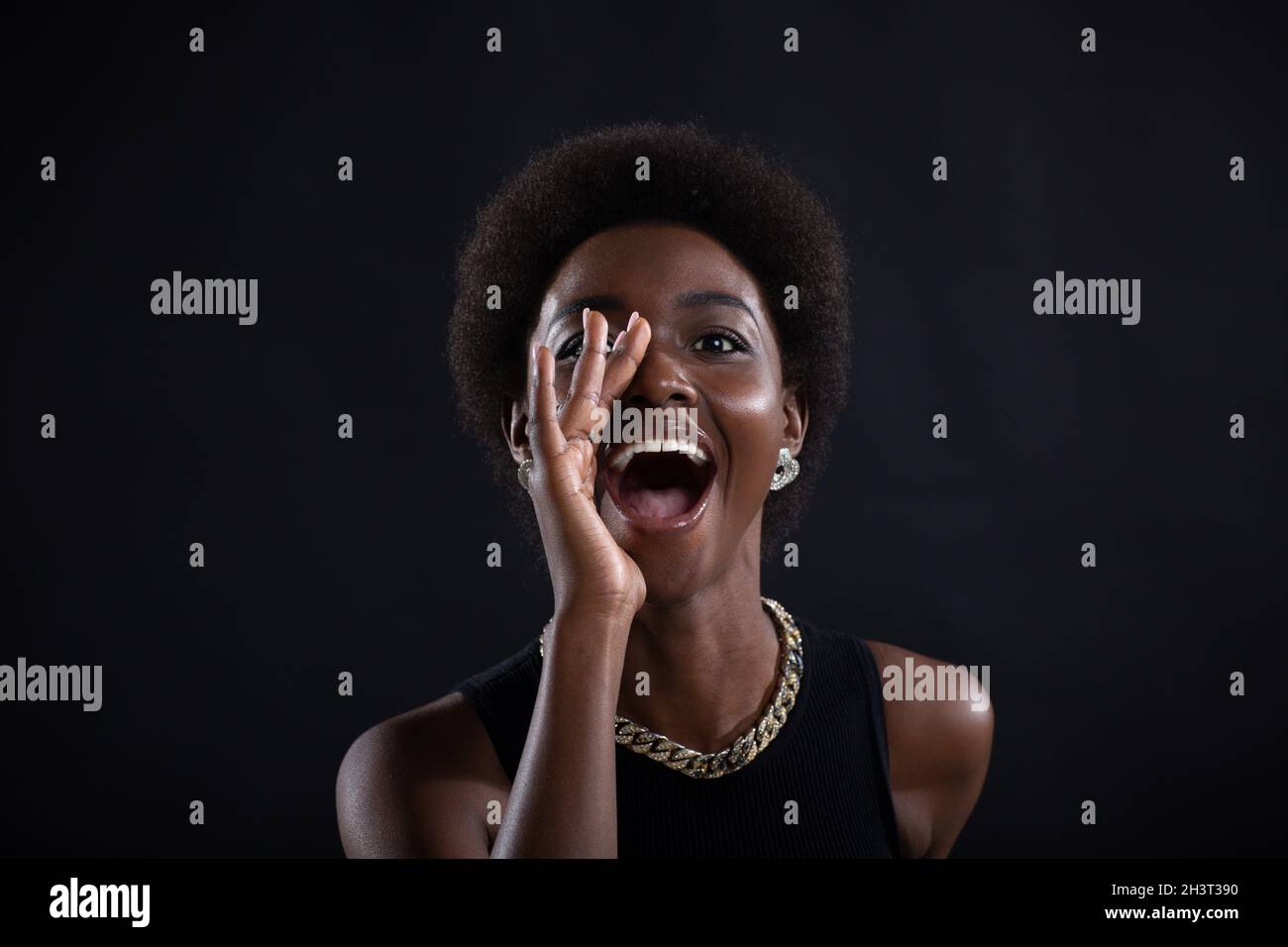 Portrait d'une femme noire tenant la main de la paume près de la large bouche ouverte criant cri Banque D'Images