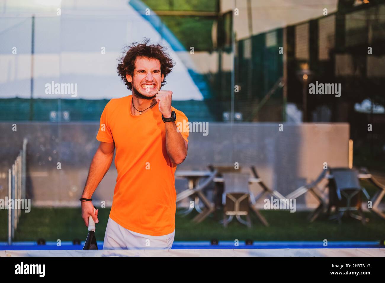 Un joueur de padel s'est exlaté après avoir remporté un match - Jeune athlète célébrant la victoire après le bon match Banque D'Images