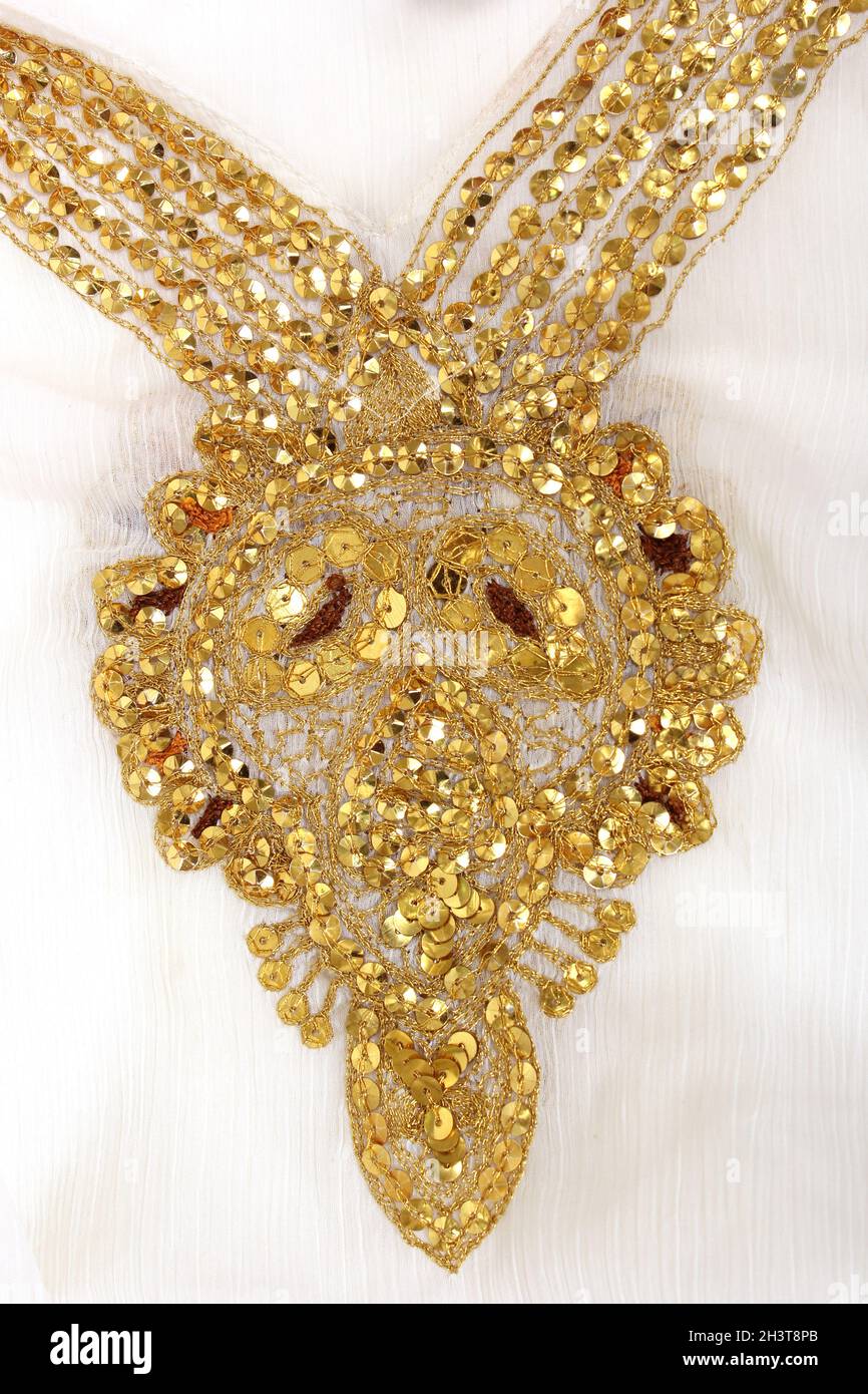 Paillettes dorées sur tissu blanc Banque D'Images