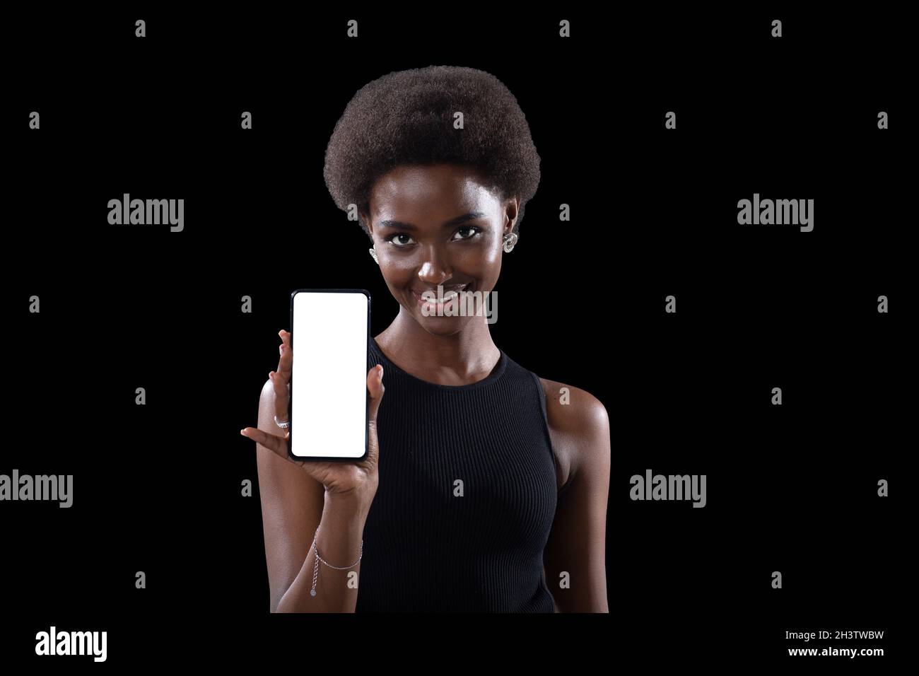 Femme noire souriante pointant avec le doigt sur un modèle vide téléphone portable écran blanc Banque D'Images
