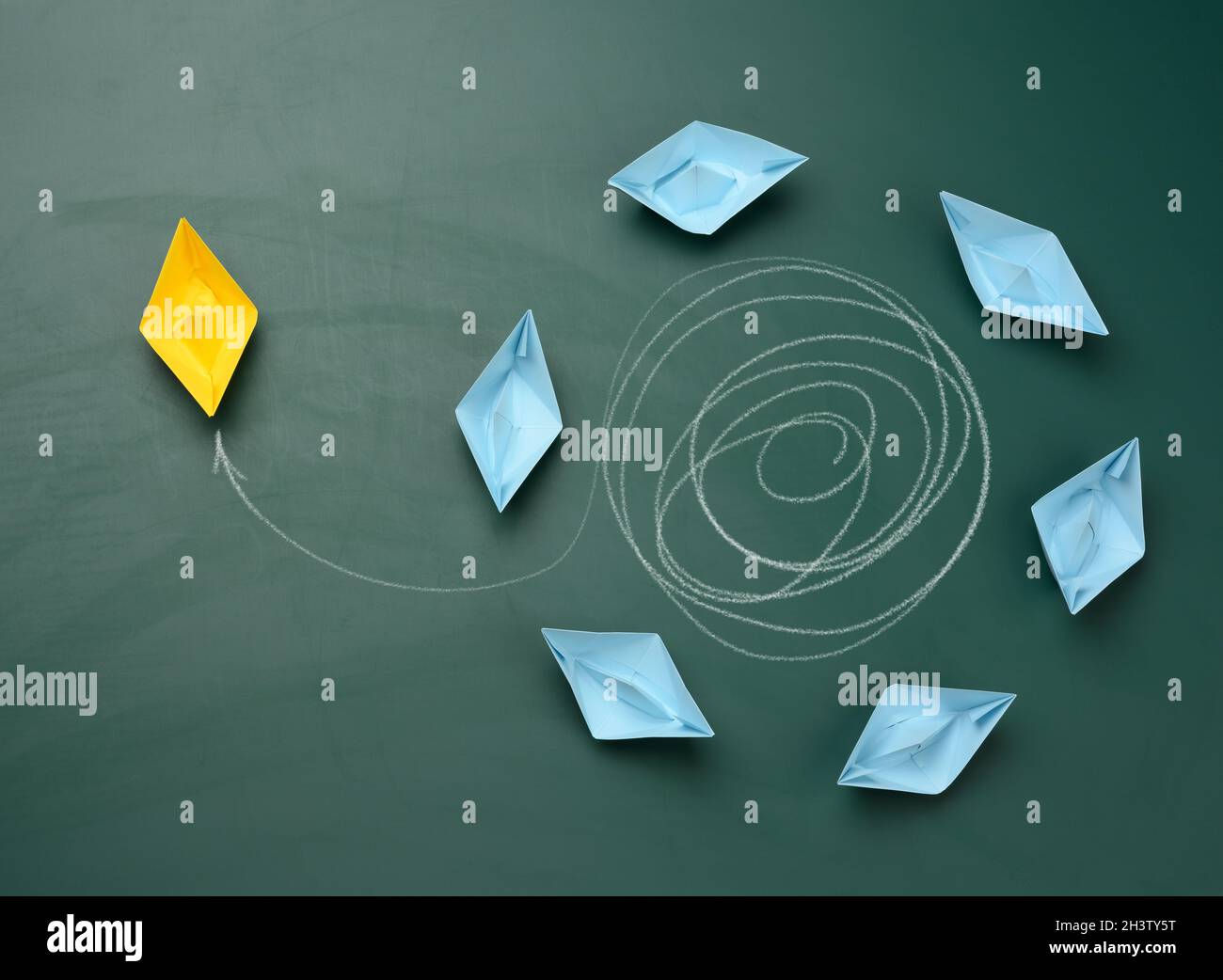 Groupe de bateaux bleus flotte dans un cercle, un jaune s'est échappé de la trajectoire et navigue dans l'autre direction Banque D'Images