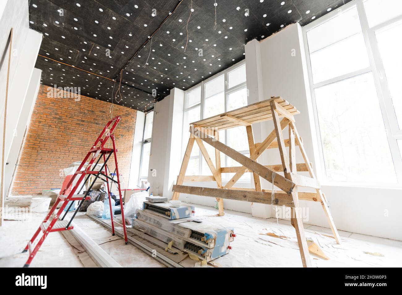 Les travailleurs installent des plaques de plâtre pour les murs de gypse dans l'appartement est en construction, remodelage, rénovation, extension, restauration et Banque D'Images