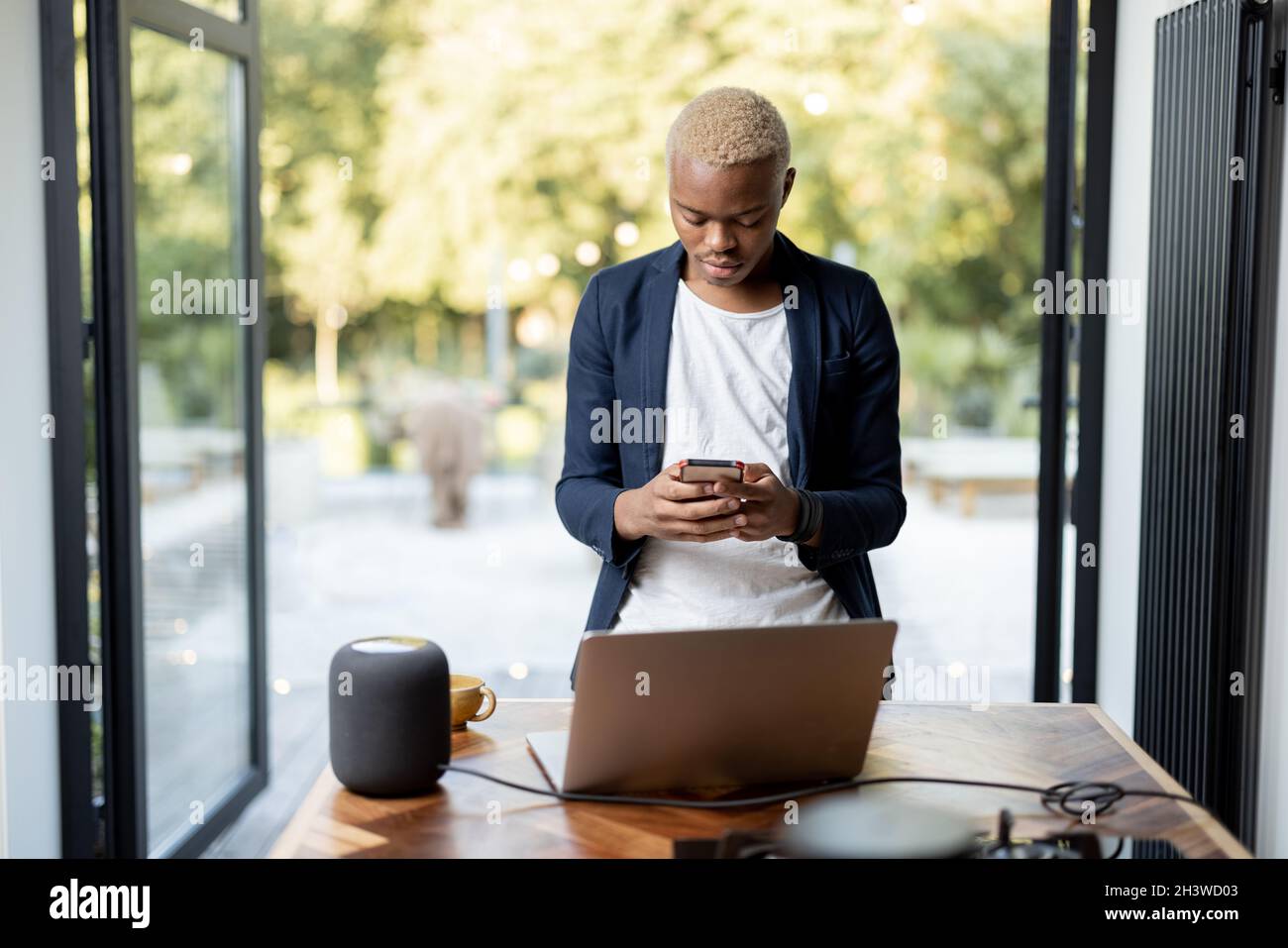 Latin homme prenant l'enceinte portable de la table Banque D'Images