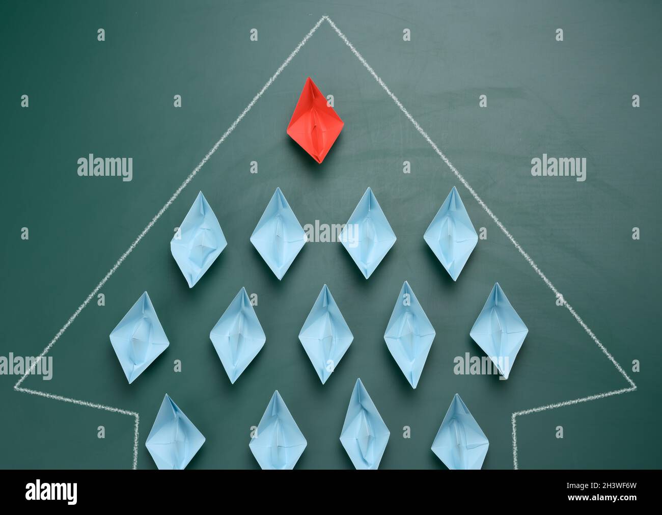 Groupe de bateaux en papier sur fond vert. Concept d'un leader fort dans une équipe, manipulation des masses, suivant de nouvelles pers Banque D'Images