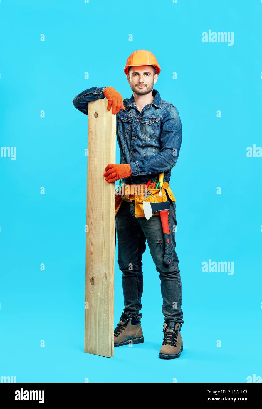 Portrait pleine longueur de jeune charpentier beau tenir pile de bois de bois de sciage Banque D'Images