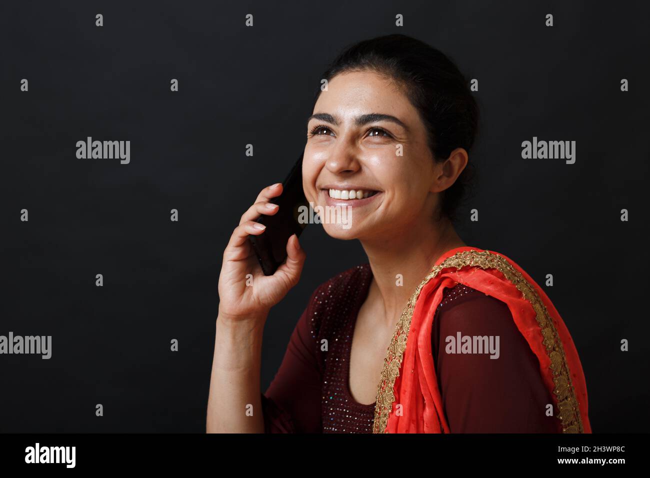 Portrait d'une jeune femme indienne adulte souriante à sari parlant téléphone mobile Banque D'Images