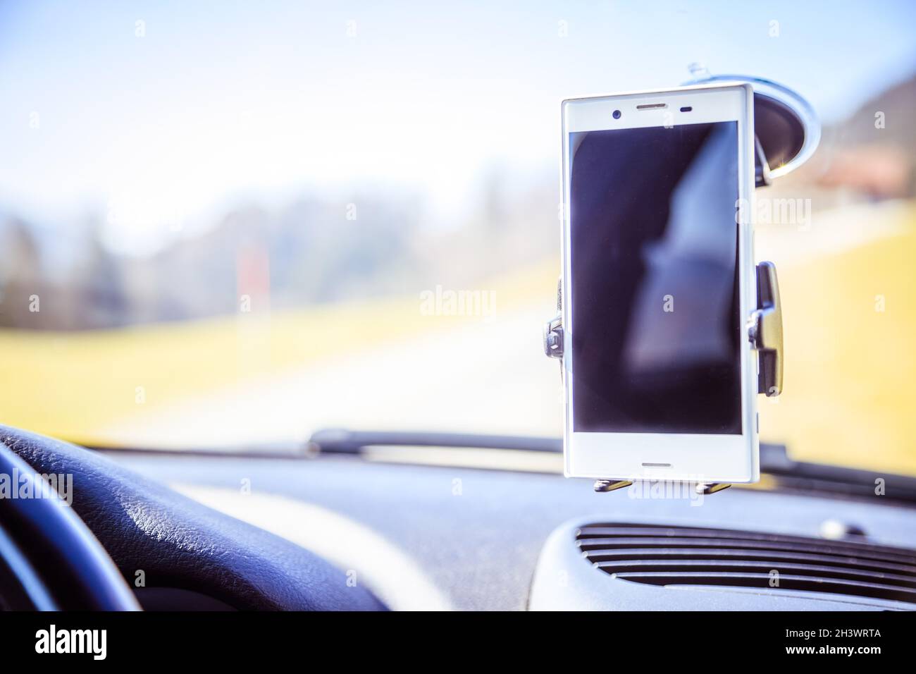 Tableau de bord de voiture avec le smartphone utilisé comme appareil de navigation, journée ensoleillée Banque D'Images