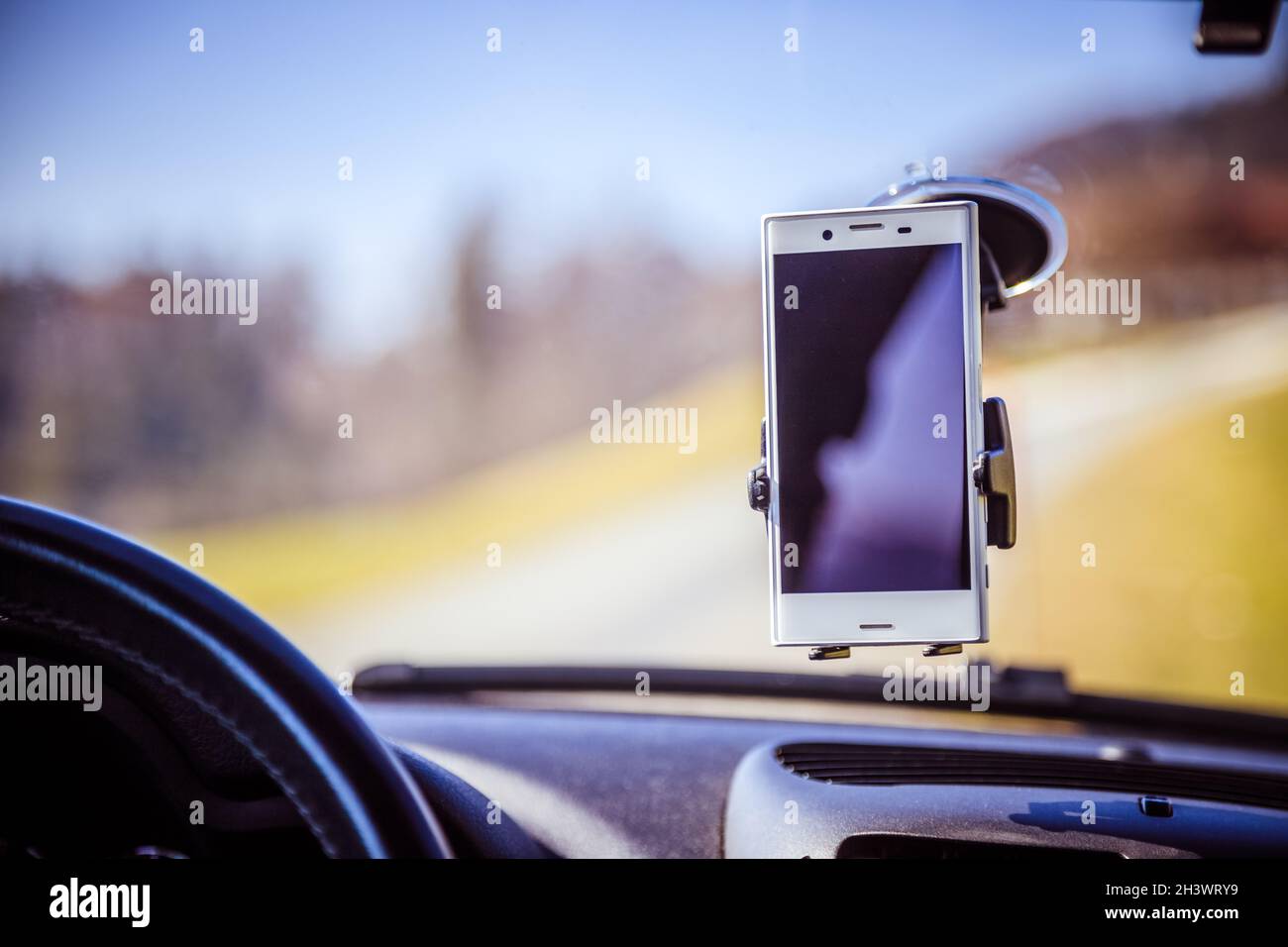 Tableau de bord de voiture avec le smartphone utilisé comme appareil de navigation, journée ensoleillée Banque D'Images