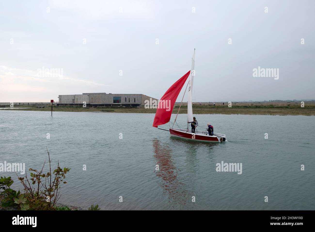 Petit voilier naviguant au-delà du Rye Discovery Centre sur la rivière Rother Rye Harbour dans l'est du Sussex Kent Angleterre KATHY DEWITT Banque D'Images