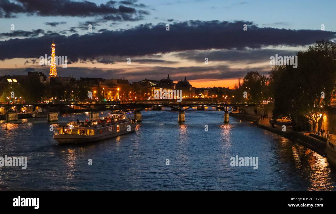 Belle nuit, Paris, Tour Eiffel étincelante, bridge pont des arts sur la Seine et les bateaux touristiques. France Banque D'Images