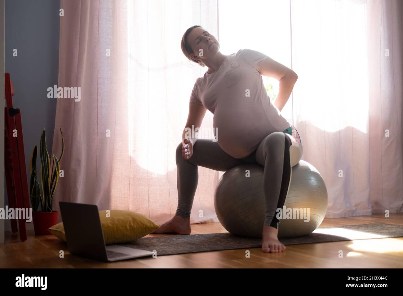 Femme enceinte s'exerçant à l'intérieur, faisant du yoga asana pour la poitrine ouverte et les épaules Banque D'Images