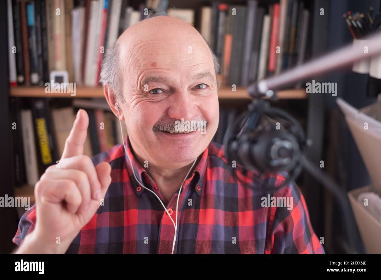 Un ancien homme à la retraite blogueur regardant la caméra donnant des conseils Banque D'Images