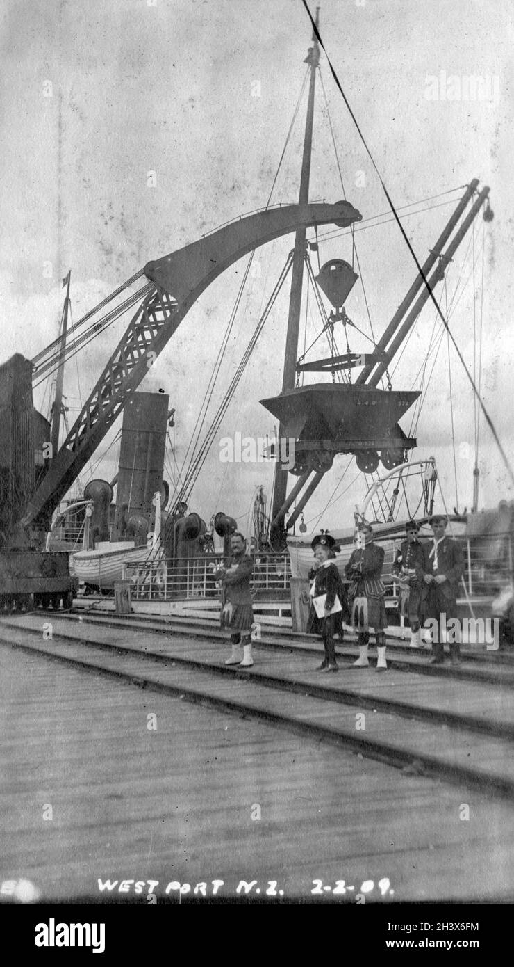 Une grue charge du charbon sur un navire au quai de Westport, en Nouvelle-Zélande, en 1909. Banque D'Images