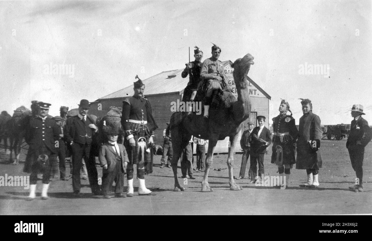 The Kilties, une bande canadienne d'Écossais, à bord d'un chameau à Leonora, en Australie occidentale, au cours de leur tournée mondiale, 1909. Banque D'Images