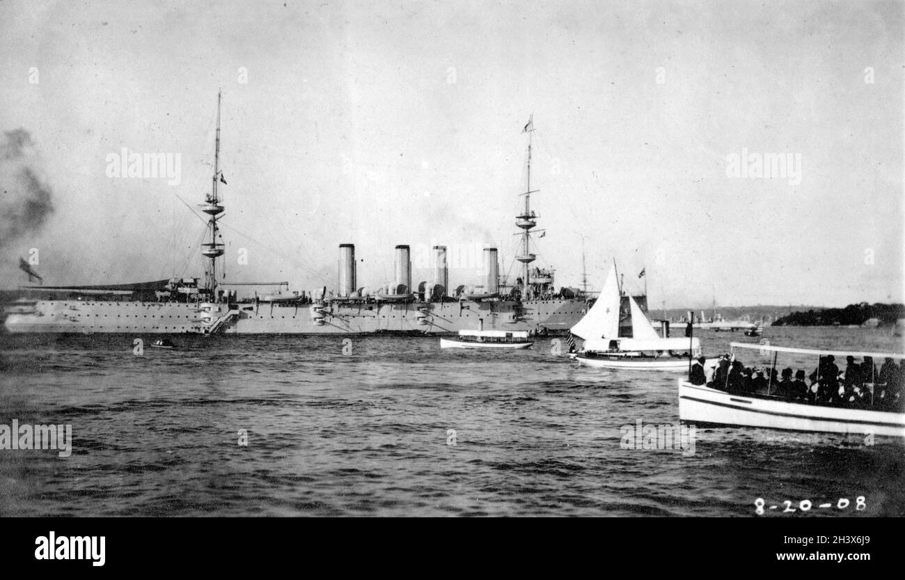 Photographie d'un cuirassé, du HMS puissant, d'un croiseur britannique et de plusieurs petits bateaux dans le port de Sydney le 20 août 1908. Banque D'Images