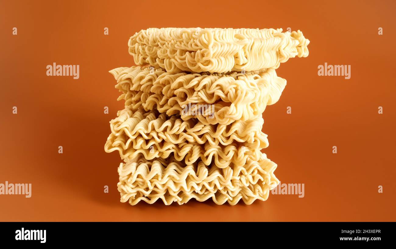 Nouilles instantanées séchées crues sur fond brun pâtes, pour la préparation dont il suffit de verser de l'eau bouillante et d'attendre Banque D'Images
