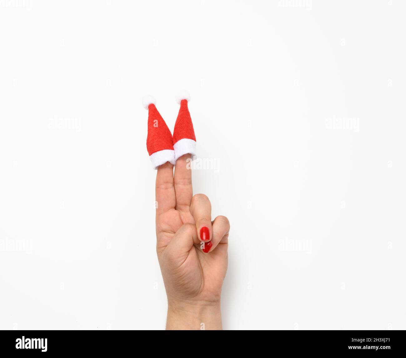 Main féminine avec de jolies casquettes rouges de noël sur les doigts, fond  blanc Photo Stock - Alamy