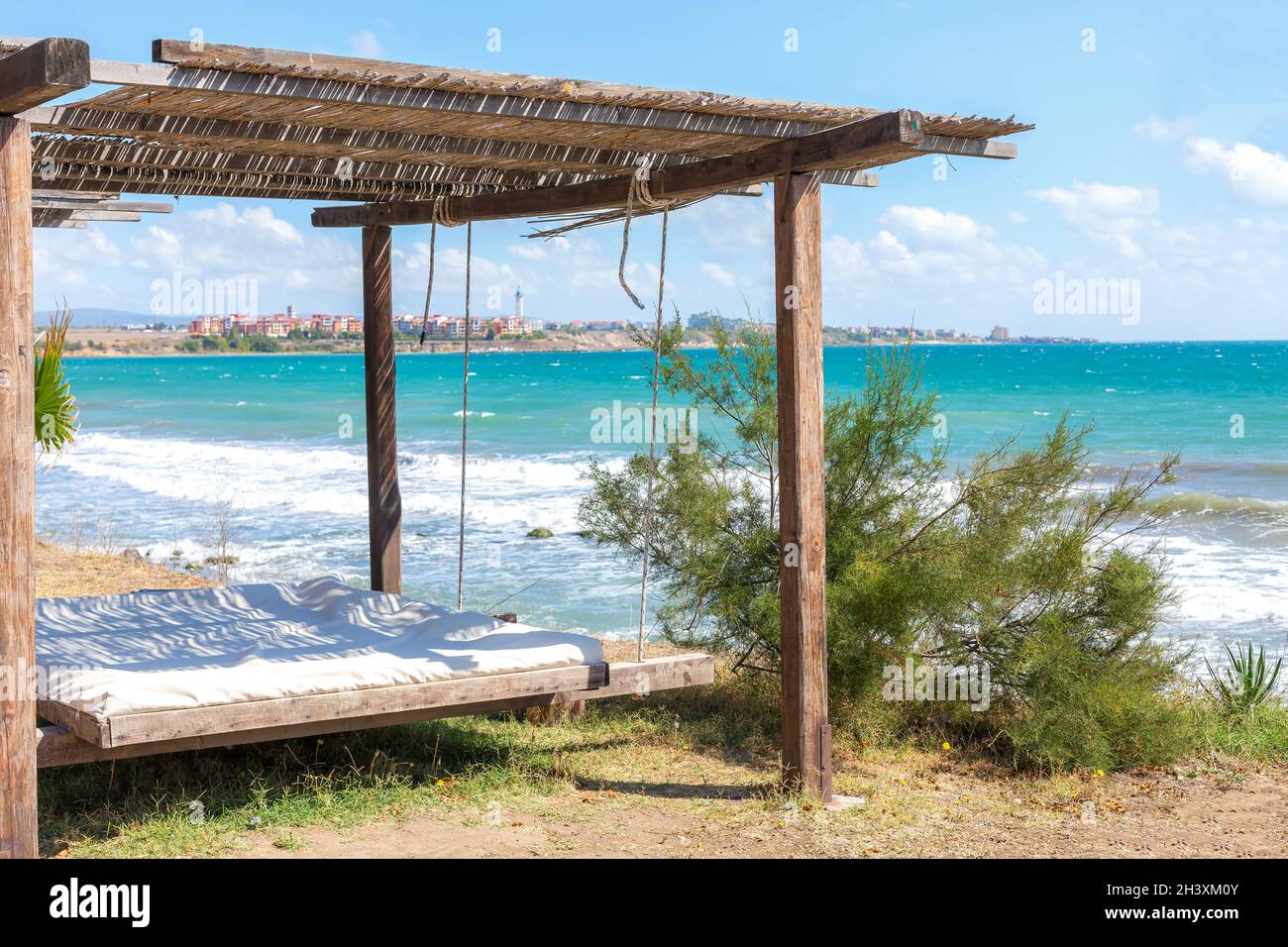 Oreiller sur le lit de plage avec salon, mer et ciel bleu Banque D'Images