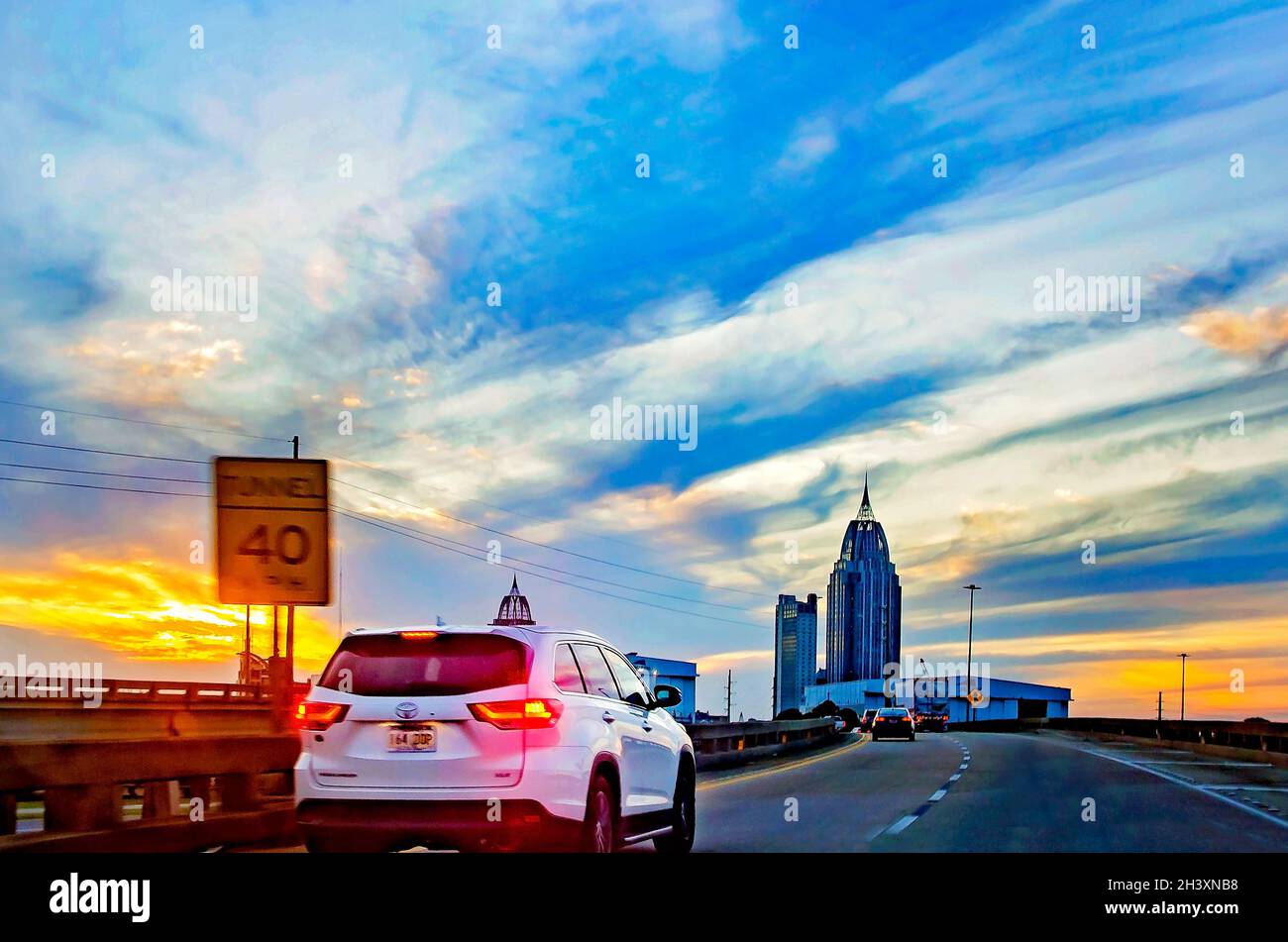 Le soleil se couche au-dessus de la ville de Mobile alors que le trafic de l'Interstate 10 se dirige vers l'ouest sur Mobile Bayway, le 23 octobre 2021, à Mobile, Alabama. Banque D'Images